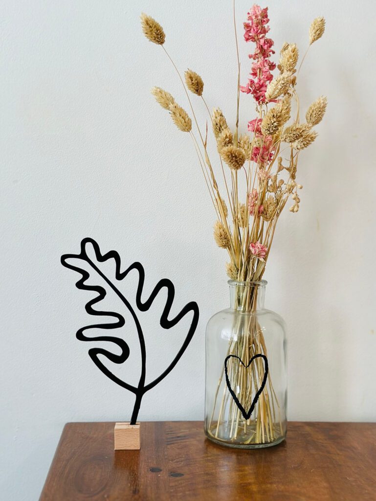 Eikenblad op tafel met bloemen in vaas