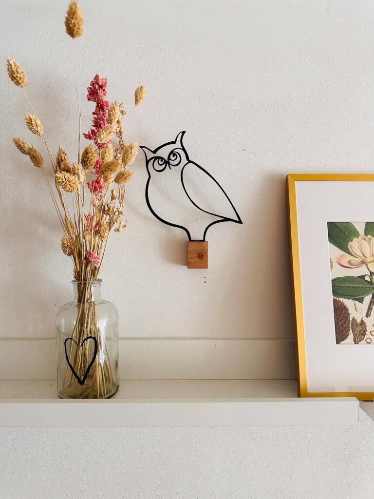 Uiltje op tafel met vaas en bloemen